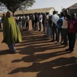 
              People line up to cast their vote in Kenya's general election in Sugoi, 50 kms (35 miles) north west of Eldoret, Kenya, Tuesday Aug. 9, 2022. Kenyans are voting to choose between opposition leader Raila Odinga Deputy President William Ruto to succeed President Uhuru Kenyatta after a decade in power. (AP Photo/Brian Inganga)
            