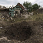 
              A crater from a Russian rocket attack is seen next to damaged homes in Kramatorsk, Donetsk region, eastern Ukraine, Saturday, Aug. 13, 2022. The strike killed three people and wounded 13 others, according to the mayor. The attack came less than a day after 11 other rockets were fired at the city, one of the two main Ukrainian-held ones in Donetsk province, the focus of an ongoing Russian offensive to capture eastern Ukraine's Donbas region. (AP Photo/David Goldman)
            