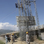 
              Government workers repair electricity cables to restore service to areas damaged by flooding, in Kanju, Swat Valley, Pakistan, Monday, Aug. 29, 2022. International aid was reaching Pakistan on Monday, as the military and volunteers desperately tried to evacuate many thousands stranded by widespread flooding driven by "monster monsoons" that have claimed more than 1,000 lives this summer. (AP Photo/Naveed Ali)
            