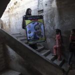 
              A relative of 11-year-old Layan al-Shaer holds a poster showing her photo, during her funeral in Khan Younis, in the Gaza Strip, Thursday, Aug. 11, 2022. On Thursday, Layan died of her wounds after she was injured in last week's Israeli air strikes. (AP Photo/Fatima Shbair)
            