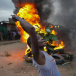 
              Shouting "No Raila No Peace," Kenyan opposition leader Raila Odinga supporters burn tIres in the Kibera neighborhood of Nairobi, Kenya, Monday, Aug. 15, 2022. Kenya’s electoral commission chairman has declared Deputy President William Ruto the winner of the close presidential election over five-time contender Raila Odinga, a triumph for the man who shook up politics by appealing to struggling Kenyans on economic terms and not on traditional ethnic ones. (AP Photo/Ben Curtis)
            