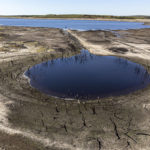 
              A cut-off water basin with dead trees is exposed at Colliford Lake, where water levels have severely dropped exposing the unseen trees and rocks at Cornwall's largest lake and reservoir, covering more than 900 acres of Bodmin Moor, Cornwall, England, Wednesday Aug. 10, 2022. The Met Office has issued an amber warning for extreme heat covering four days from Thursday to Sunday for parts of England and Wales as a new heatwave looms. (Ben Birchall/PA via AP)
            