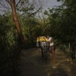 
              Yorbin Valle transports a crate of bananas on a bike as he crosses through illegal trails called in Spanish "trochas", at the La Parada neighborhood, near the border with Venezuela, in Cucuta, Colombia, Saturday, Aug. 6, 2022. The border will gradually reopen after the two nations restore diplomatic ties when Colombia's new president is sworn-in on Aug. 7, according to announcement in late July by Colombia's incoming Foreign Minister Alvaro Leyva and Venezuelan Foreign Minister Carlos Faria. (AP Photo/Matias Delacroix)
            