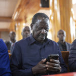 
              Presidential candidate Raila Odinga checks his phone as he attends Sunday mass in St. Francis church in Nairobi, Kenya, Sunday, Aug. 14, 2022. The race remains close between Odinga and Deputy President William Ruto as the electoral commission physically verifies more than 46,000 results forms electronically transmitted from around the country. (AP Photo/Mosa'ab Elshamy)
            