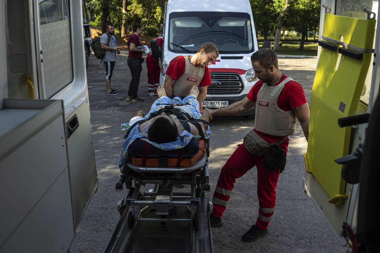 Volunteers of the Ukrainian Red Cross emergency transport a wounded man from one to another hospita...