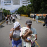 
              A Venezuelan couple use the Francisco De Paula Santander Bridge to cross between Urena, Venezuela and Cucuta, Colombia, Saturday, Aug. 6, 2022. The border will gradually reopen after the two nations restore diplomatic ties when Colombia's new president is sworn-in on Aug. 7, according to announcement in late July by Colombia's incoming Foreign Minister Alvaro Leyva and Venezuelan Foreign Minister Carlos Faria. (AP Photo/Matias Delacroix)
            