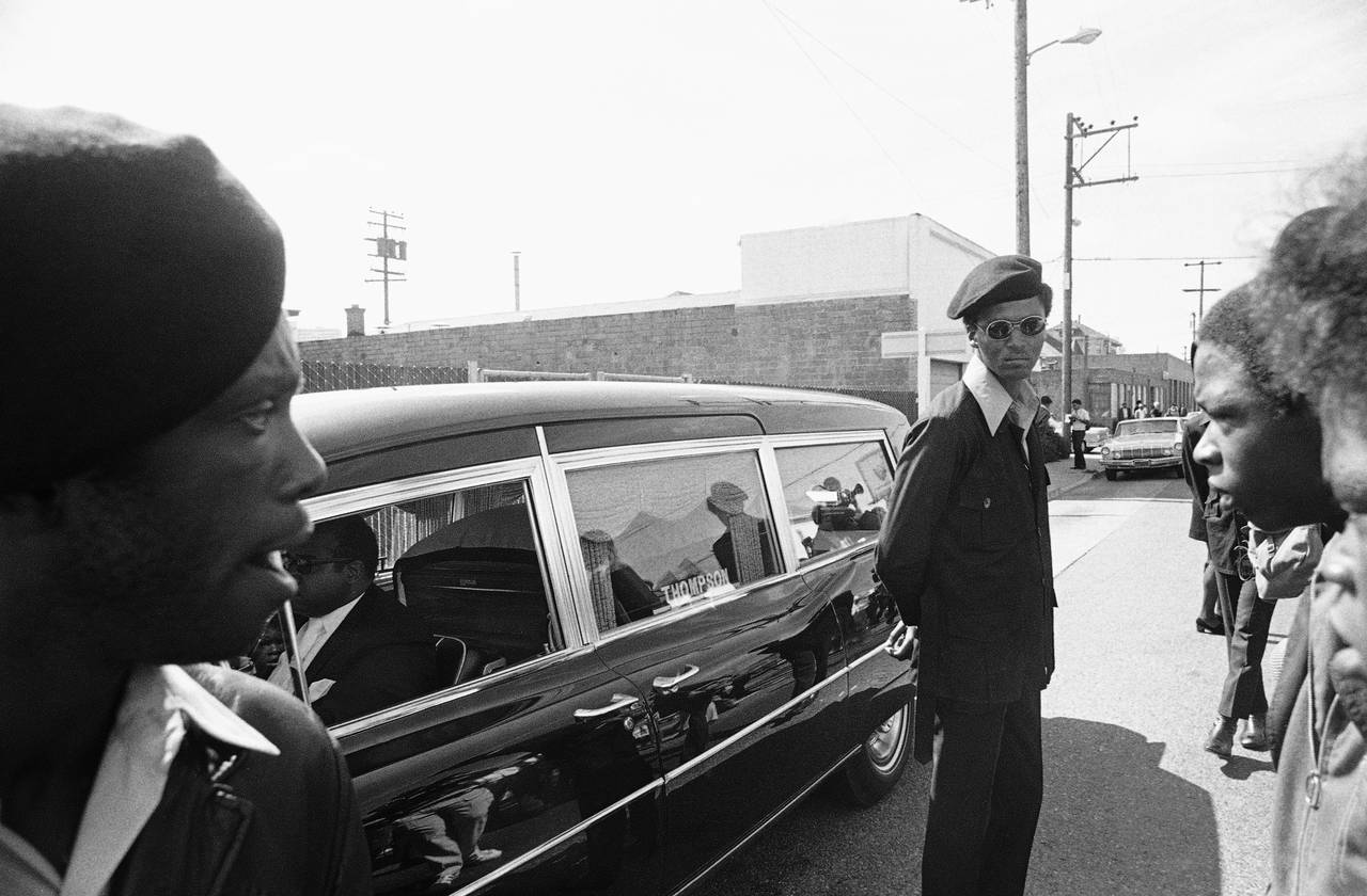 FILE - Black Panthers stand guard on Aug. 28, 1971, in Oakland, Calif., while the hearse carrying t...
