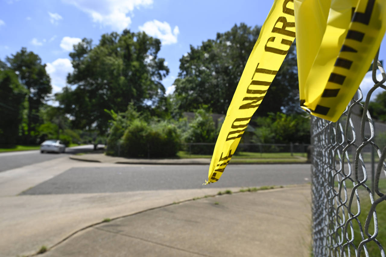 FILE - A remnant of crime scene tape hangs on a fence in the neighborhood of Whitehaven in Memphis,...