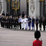 
              Buckingham Palace staff stand outside its gates during Queen Elizabeth II funeral ceremonies in central London Monday, Sept. 19, 2022. The Queen, who died aged 96 on Sept. 8, will be buried at Windsor alongside her late husband, Prince Philip, who died last year. (AP Photo/Christophe Ena, Pool)
            