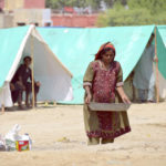 
              A pregnant woman carries water as she take a refuge at a camp after leaving her flood-hit homes, in Jaffarabad, a district of Baluchistan province, Pakistan, Wednesday, Sept. 21, 2022. Devastating floods in Pakistan's worst-hit province have killed 10 more people in the past day, including four children, officials said Wednesday as the U.N. children's agency renewed its appeal for $39 million to help the most vulnerable flood victims. (AP Photo/Zahid Hussain)
            