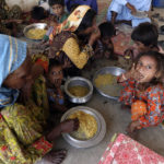 
              Victims of the unprecedented flooding from monsoon rains receive relief food organized by the Alkhidmat Foundation, in Jaffarabad, a district of Pakistan's southwestern Baluchistan province, Monday, Sept. 5, 2022. The U.N. refugee agency rushed in more desperately needed aid Monday to flood-stricken Pakistan as the nation's prime minister traveled to the south where rising waters of Lake Manchar pose a new threat. (AP Photo/Fareed Khan)
            