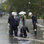 
              Workers check drainage hole at a square as Typhoon Hinnamnor travels toward the Korean Peninsula in Seoul, South Korea, Monday, Sept. 5, 2022. Hundreds of flights were grounded and more than 200 people evacuated in South Korea on Monday as Typhoon Hinnamnor approached the country's southern region with heavy rains and winds of up to 290 kilometers (180 miles) per hour, the strongest storm in decades. (AP Photo/Lee Jin-man)
            