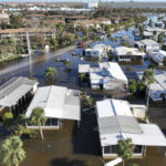 
              Rescue personnel search a flooded trailer park after Hurricane Ian passed by the area Thursday, Sept. 29, 2022, in Fort Myers, Fla. (AP Photo/Steve Helber)
            