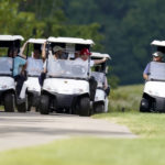 
              Former President Donald Trump, center cart, rides around his golf course at Trump National Golf Club in Sterling, Va., Monday, Sept. 12, 2022. (AP Photo/Alex Brandon)
            