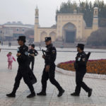 
              FILE - Uyghur security personnel patrol near the Id Kah Mosque in Kashgar in western China's Xinjiang region, Nov. 4, 2017. China's discriminatory detention of Uyghurs and other mostly Muslim ethnic groups in the western region of Xinjiang may constitute crimes against humanity, the U.N. human rights office said in a long-awaited report Wednesday, Aug. 31, 2022, which cited "serious" rights violations and patterns of torture in recent years. (AP Photo/Ng Han Guan, File)
            