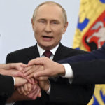 
              Russian President Vladimir Putin joins hands with Moscow-appointed head of Kherson Region Vladimir Saldo, Moscow-appointed head of Zaporizhzhia region Yevgeny Balitsky, Denis Pushilin, leader of self-proclaimed Donetsk People's Republic and Leonid Pasechnik, leader of self-proclaimed Luhansk People's Republic, as they celebrate at the Kremlin during a ceremony to sign the treaties for four regions of Ukraine to join Russia, in Moscow, Friday, Sept. 30, 2022. The signing of the treaties making the four regions part of Russia follows the completion of the Kremlin-orchestrated "referendums." (Grigory Sysoyev, Sputnik, Government Pool Photo via AP)
            