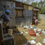 
              Two women walk through stagnant water in their homes caused by Hurricane Fiona in the Los Sotos neighborhood in Higüey, Dominican Republic, Tuesday, Sept. 20, 2022. (AP Photo/Ricardo Hernandez)
            