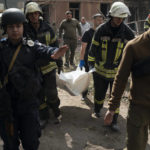 
              Firefighters carry a bag containing a body of a person after a Russian attack that heavily damaged a residential building in Sloviansk, Ukraine, Wednesday, Sept. 7, 2022. (AP Photo/Leo Correa)
            