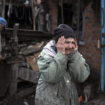 
              Valentina Bondarenko reacts as she stands with her husband Leonid outside their house that was heavily damaged after a Russian attack in Sloviansk, Ukraine, Tuesday, Sept. 27, 2022. The 78-year-old woman was at garden and fell on the ground at the moment of the explosion. "Everything flew and I started to run away", says Valentina. (AP Photo/Leo Correa)
            