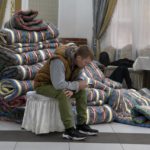 
              A Russian man rests in at temporary accommodation facility after crossing the border into Kazakhstan from the Mariinsky border crossing, about 400 km (250 miles) south of Chelyabinsk, in Russia, to Kazakhstan's town Ata-Meken, about 1400 km (250 miles) east of Astana, the capital of Kazakhstan, Wednesday, Sept. 28, 2022. Russians have crossed into Kazakhstan in the week since President Vladimir Putin announced a partial mobilization of reservists to fight in Ukraine, Kazakh officials said Tuesday, as men seeking to avoid the call-up continued to flee by land and air into neighboring countries. (AP Photo/Denis Spiridonov)
            