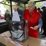 
              A woman votes during a referendum in a mobile polling station in Mariupol, Donetsk People's Republic, controlled by Russia-backed separatists, eastern Ukraine, Friday, Sept. 23, 2022. Voting began Friday in four Moscow-held regions of Ukraine on referendums to become part of Russia. (AP Photo)
            