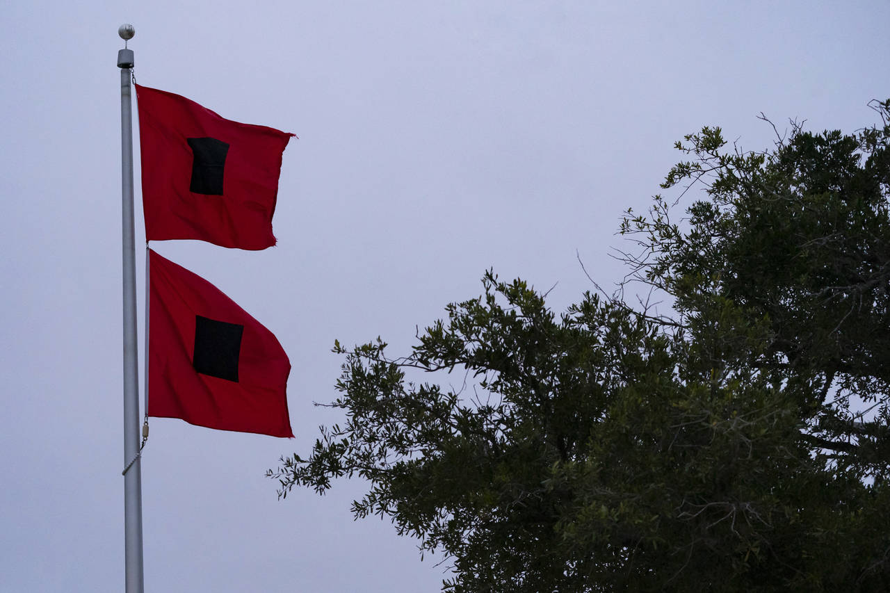 Hurricane warning flags fly in front of the fire station and town hall as the effects from Hurrican...