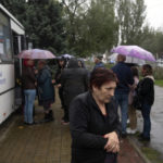 
              People lineup to attend voting in referendum in front of mobile polling station in Luhansk, Ukraine, Friday, Sept. 23, 2022. Voting began Friday in four Moscow-held regions of Ukraine on referendums to become part of Russia. (AP Photo/)
            