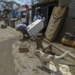 
              Neighbors work to recover their belongings from the flooding caused by Hurricane Fiona in the Los Sotos neighborhood of Higüey, Dominican Republic, Tuesday, Sept. 20, 2022. (AP Photo/Ricardo Hernandez)
            