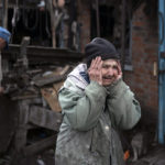 
              Valentina Bondarenko reacts as she stands with her husband Leonid outside their house that was heavily damaged after a Russian attack in Sloviansk, Ukraine, Tuesday, Sept. 27, 2022. The 78-year-old woman was in the garden and fell on the ground at the moment of the explosion. "Everything flew and I started to run away", says Valentina. (AP Photo/Leo Correa)
            