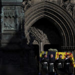 
              Pallbearers carry the coffin of Britain's Queen Elizabeth II outside St. Giles Cathedral, in Edinburgh, Scotland, Tuesday, Sept. 13, 2022. King Charles III and Camilla, the Queen Consort, flew to Belfast from Edinburgh on Tuesday, the same day the queen’s coffin will be flown to London from Scotland. (Carl Recine/Pool Photo via AP)
            