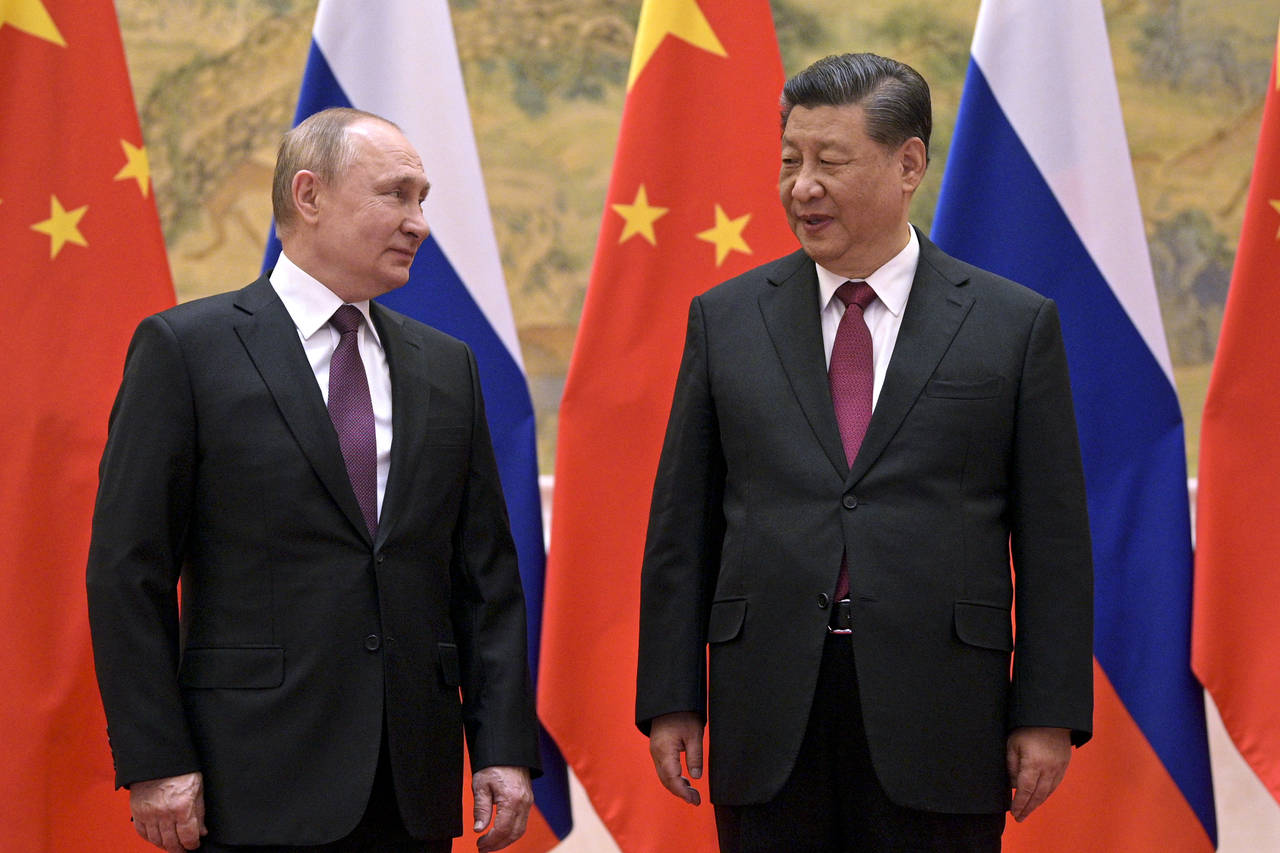 FILE - Chinese President Xi Jinping, right, and Russian President Vladimir Putin talk to each other...