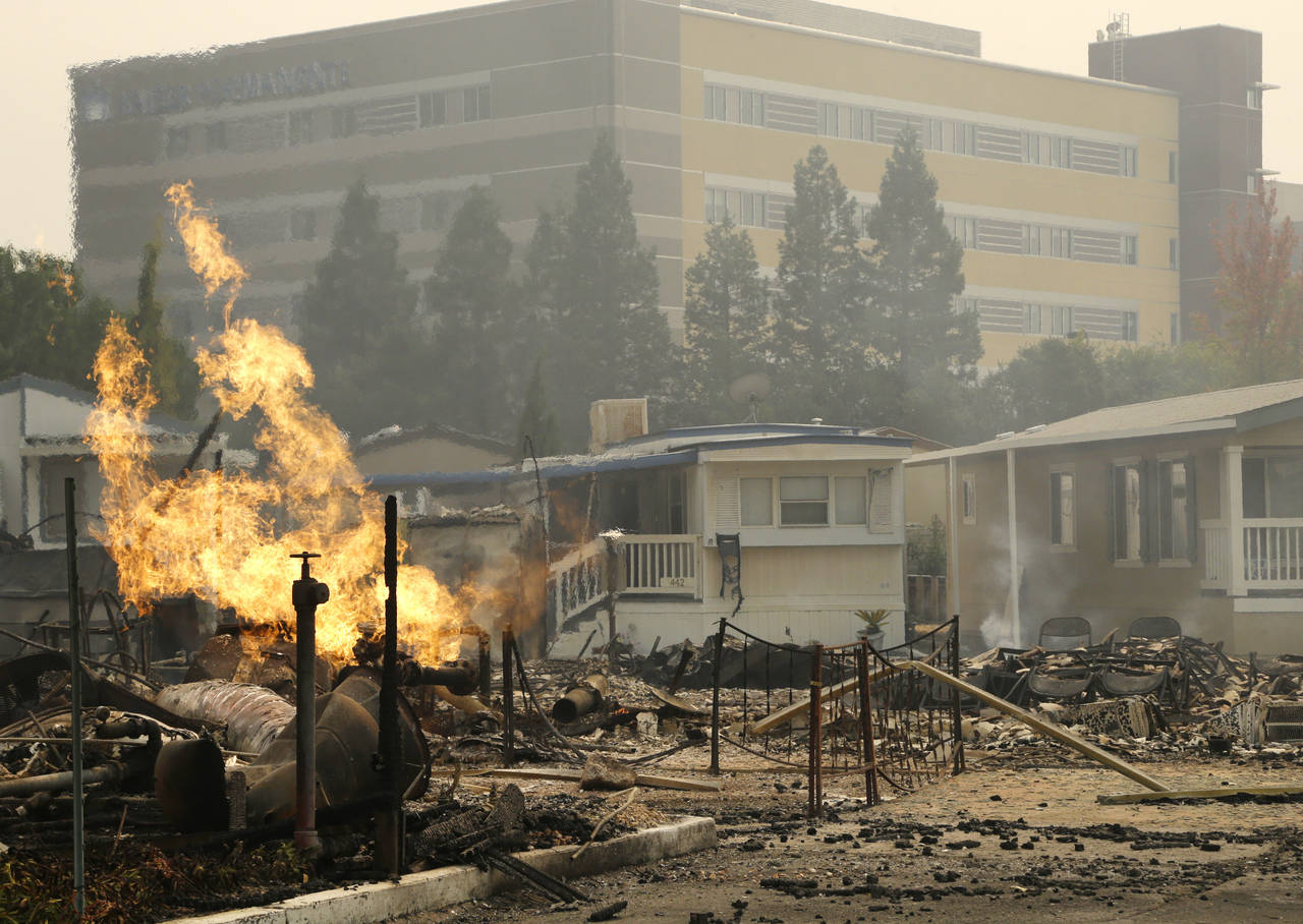 FILE - With Kaiser Permanente’s Santa Rosa Medical Center in the background, a flame from an open...