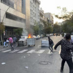 
              In this Tuesday, Sept. 20, 2022, photo taken by an individual not employed by the Associated Press and obtained by the AP outside Iran, protesters throw stones at anti-riot police during a protest over the death of a young woman who had been detained for violating the country's conservative dress code, in downtown Tehran, Iran. Iran faced international criticism on Tuesday over the death of a woman held by its morality police, which ignited three days of protests, including clashes with security forces in the capital and other unrest that claimed at least three lives. (AP Photo)
            