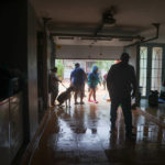 
              People clean a house flooded by the rains of Hurricane Fiona in Cayey, Puerto Rico, Sunday, Sept. 18, 2022. (AP Photo/Stephanie Rojas)
            