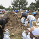 
              Residents and city workers fill sandbags at West Park in downtown Clermont, Fla., Tuesday, Sept. 27, 2022, in preparation for Hurricane Ian. (Rich Pope/Orlando Sentinel via AP)
            