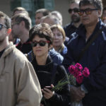 
              A woman holding flowers look on as she lines up to pay the last respects at the coffin of former Soviet President Mikhail Gorbachev outside the Pillar Hall of the House of the Unions during a farewell ceremony in Moscow, Russia, Saturday, Sept. 3, 2022. Gorbachev, who died Tuesday at the age of 91, will be buried at Moscow's Novodevichy cemetery next to his wife, Raisa, following a farewell ceremony at the Pillar Hall of the House of the Unions, an iconic mansion near the Kremlin that has served as the venue for state funerals since Soviet times. (AP Photo)
            