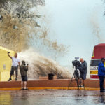 News crews, tourists and local residents take images as high waves from Hurricane Ian crash into the seawall at the Southernmost Point buoy, Tuesday, Sept. 27, 2022, in Key West, Fla. Ian was forecast to strengthen even more over warm Gulf of Mexico waters, reaching top winds of 140 mph (225 kmh) as it approaches the Florida's southwest coast. (Rob O'Neal/The Key West Citizen via AP)
