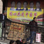 
              FILE - Residents transport goods past a mural depicting current and past top Chinese leaders including Chinese President Xi Jinping at right and Mao Zedong at left in Hotan in western China's Xinjiang region on Nov. 3, 2017. Chinese characters in red reads "Building a Chinese Dream Together." China has responded furiously to a United Nations report on alleged human rights abuses in its northwestern Xinjiang region targeting Uyghurs and other mainly Muslim ethnic minorities. (AP Photo/Ng Han Guan, File)
            