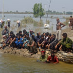 
              Victims of heavy flooding from monsoon rains wait to receive relief aid from the Pakistani Army in the Qambar Shahdadkot district of Sindh Province, Pakistan, Friday, Sept. 9, 2022. U.N. Secretary-General Antonio Guterres appealed to the world for help for cash-strapped Pakistan after arriving in the country Friday to see the climate-induced devastation from months of deadly record floods. (AP Photo/Fareed Khan)
            