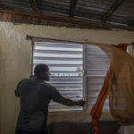 
              Nelson Cirino secures the windows of his home as the winds of Hurricane Fiona blow in Loiza, Puerto Rico, Sunday, Sept. 18, 2022. (AP Photo/Alejandro Granadillo)
            