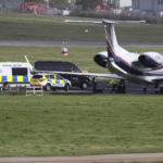 
              Police work with dogs under the belly of a private plane on the tarmac of Aberdeen airport in Aberdeen, Scotland, Friday, Sept. 9, 2022. Queen Elizabeth II, Britain's longest-reigning monarch and a rock of stability across much of a turbulent century, died Thursday after 70 years on the throne. She was 96. (AP Photo/Scott Heppell)
            