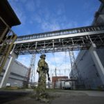 
              FILE - A Russian serviceman guards an area of the Zaporizhzhia Nuclear Power Station in territory under Russian military control, southeastern Ukraine, May 1, 2022. Ukraine’s Zaporizhzhia nuclear power plant , built during the Soviet era and one of the 10 biggest in the world, has been engulfed by fighting between Russian and Ukrainian troops in recent weeks, fueling concerns of a nuclear catastrophe. (AP Photo, File)
            