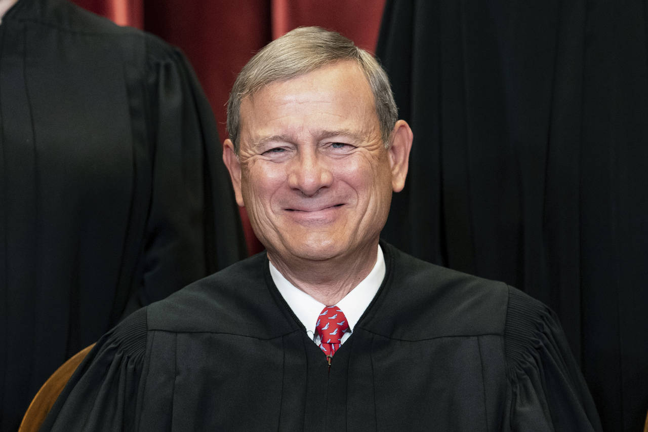 FILE - Chief Justice John Roberts sits during a group photo at the Supreme Court in Washington, Apr...