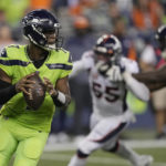 
              Seattle Seahawks quarterback Geno Smith, left, drops to pass against the Denver Broncos during the second half of an NFL football game, Monday, Sept. 12, 2022, in Seattle. The Seahawks won 17-16. (AP Photo/Stephen Brashear)
            