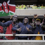 
              Supporters gather in the stands, one of them waving a national flag, as they await the inauguration of Kenya's new president William Ruto due to take place later today, at Kasarani stadium in Nairobi, Kenya Tuesday, Sept. 13, 2022. A number of people were crushed and injured as Kenyans on Tuesday forced their way into the stadium. (AP Photo/Brian Inganga)
            