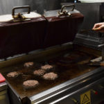 
              A worker cooks burgers at Zing Burger store in Budapest, Hungary, Monday, Sept. 12, 2022. Richard Kovacs, a business development manager for the Hungarian burger chain, said some of the chain's 15 stores have seen a 750% increase in electricity bills since the beginning of the year – leading to additional monthly costs of up to 1.5 million Hungarian forints ($3,840) per store. (AP Photo/Anna Szilagyi)
            