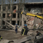 
              Rescue workers clear the debris at the scene where a woman was found dead after a Russian attack that heavily damaged a school in Mykolaivka, Ukraine, Wednesday, Sept. 28, 2022. (AP Photo/Leo Correa)
            