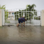 
              A woman clears debris on her property flooded by Hurricane Fiona in Salinas, Puerto Rico, Monday, Sept. 19, 2022. (AP Photo/Alejandro Granadillo)
            