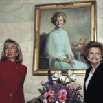 
              FILE - First lady Hillary Rodham Clinton poses with former first lady Betty Ford under Ford's White House portrait in Washington, March 2, 1993. (AP Photo/Ron Edmonds, File)
            
