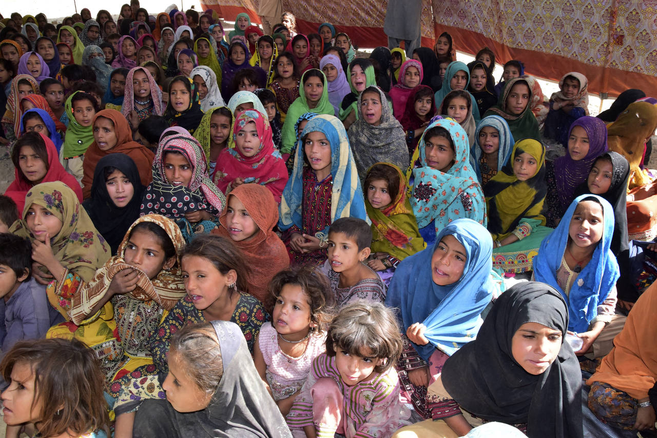 Victims of heavy flooding from monsoon rains attend class at a relief camp in Dasht near Quetta, Pa...